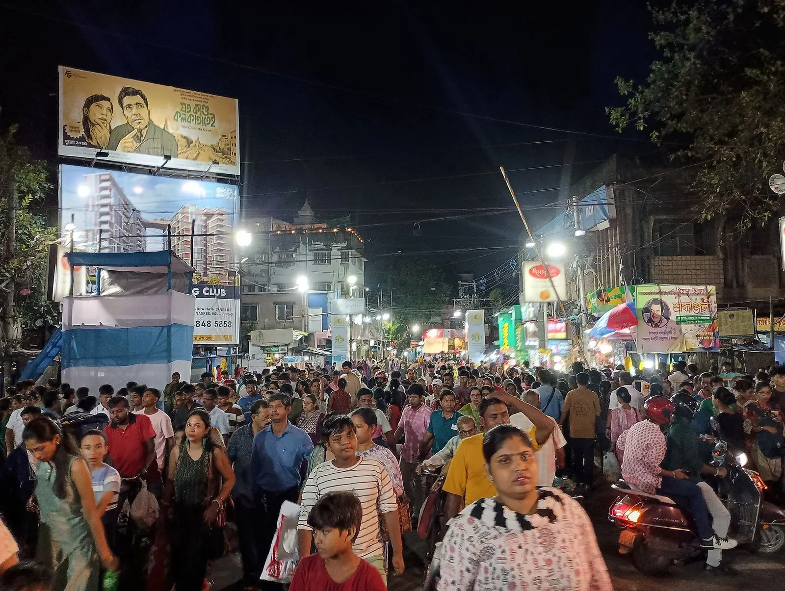 Crowds walking between Durga Puja pandals at night – zone-wise pandal map 2026